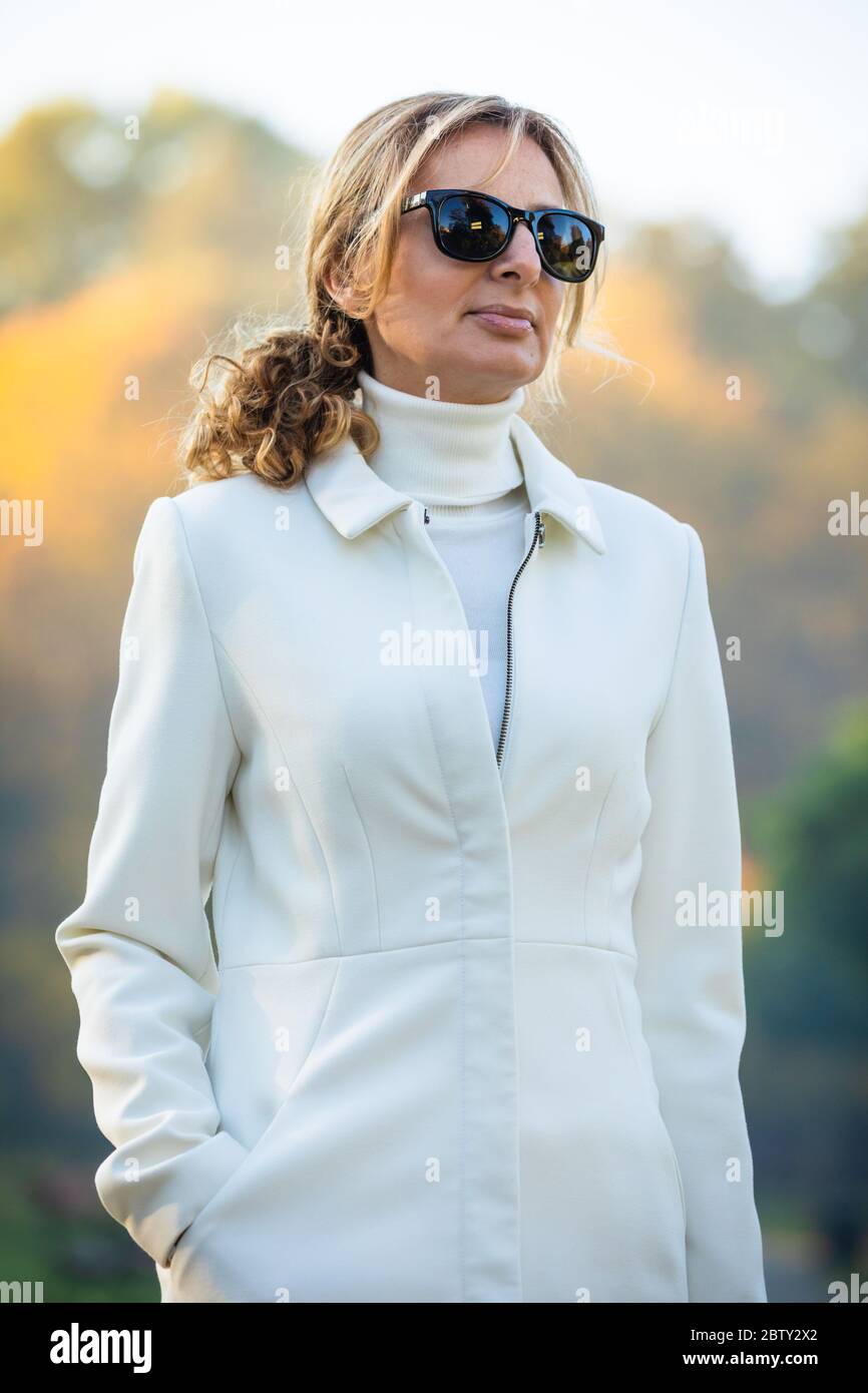 Middle-aged woman walking in city park Stock Photo