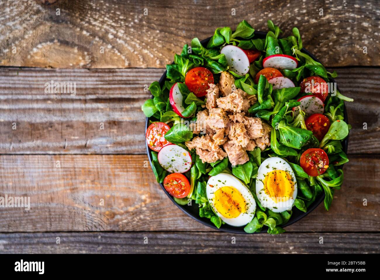 Tuna salad on wooden table Stock Photo