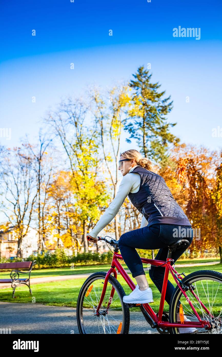 Urban biking - woman riding bike in city park Stock Photo