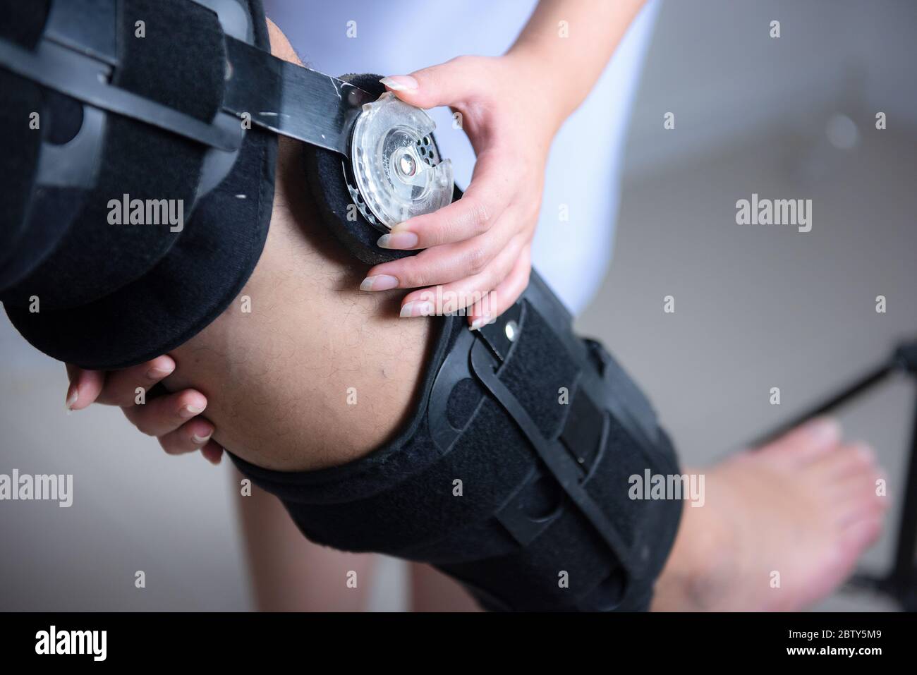 Physical therapists adjust the knee brace to the patient's Stock Photo