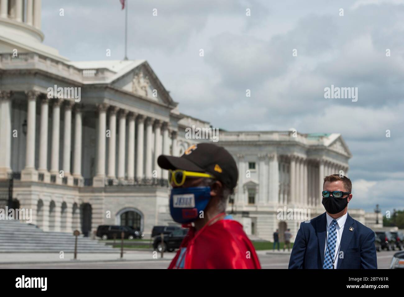 Michael Wheeler, of Kansas City, MO, (left) wears his 'Super Jesus' outfit and face mask while a US Capitol Security detail stands at right as House Minority Leader Rep. Kevin McCarthy (R-Calif.) holds a media availability with House Minority Whip Rep. Steve Scalise (R-LA), House GOP Conference Chairwoman Liz Cheney (R-WY) and others, to announce that Republican leaders have filed a lawsuit against House Speaker Nancy Pelosi and congressional officials in an effort to block the House of Representatives from using a proxy voting system to allow for remote voting during the coronavirus pandemic, Stock Photo