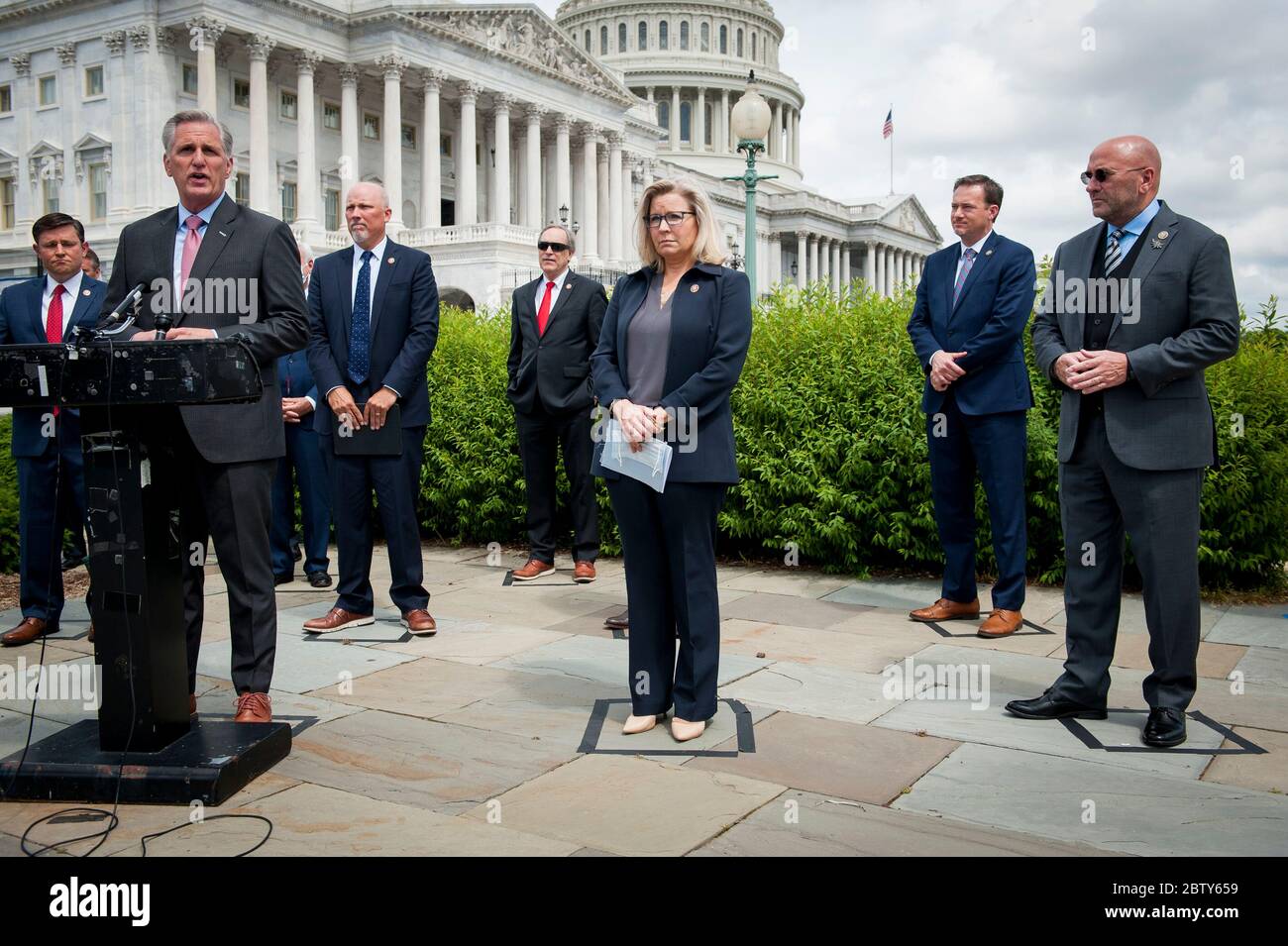 GOP Conference Chairwoman Liz Cheney (R-WY, center) stands in her taped off safe distancing square and listens while House Minority Leader Rep. Kevin McCarthy (R-Calif., left) holds a media availability to announce that Republican leaders have filed a lawsuit against House Speaker Nancy Pelosi and congressional officials in an effort to block the House of Representatives from using a proxy voting system to allow for remote voting during the coronavirus pandemic, outside of the U.S. Capitol in Washington, DC., Wednesday, May 27, 2020. Credit: Rod Lamkey/CNP /MediaPunch Stock Photo