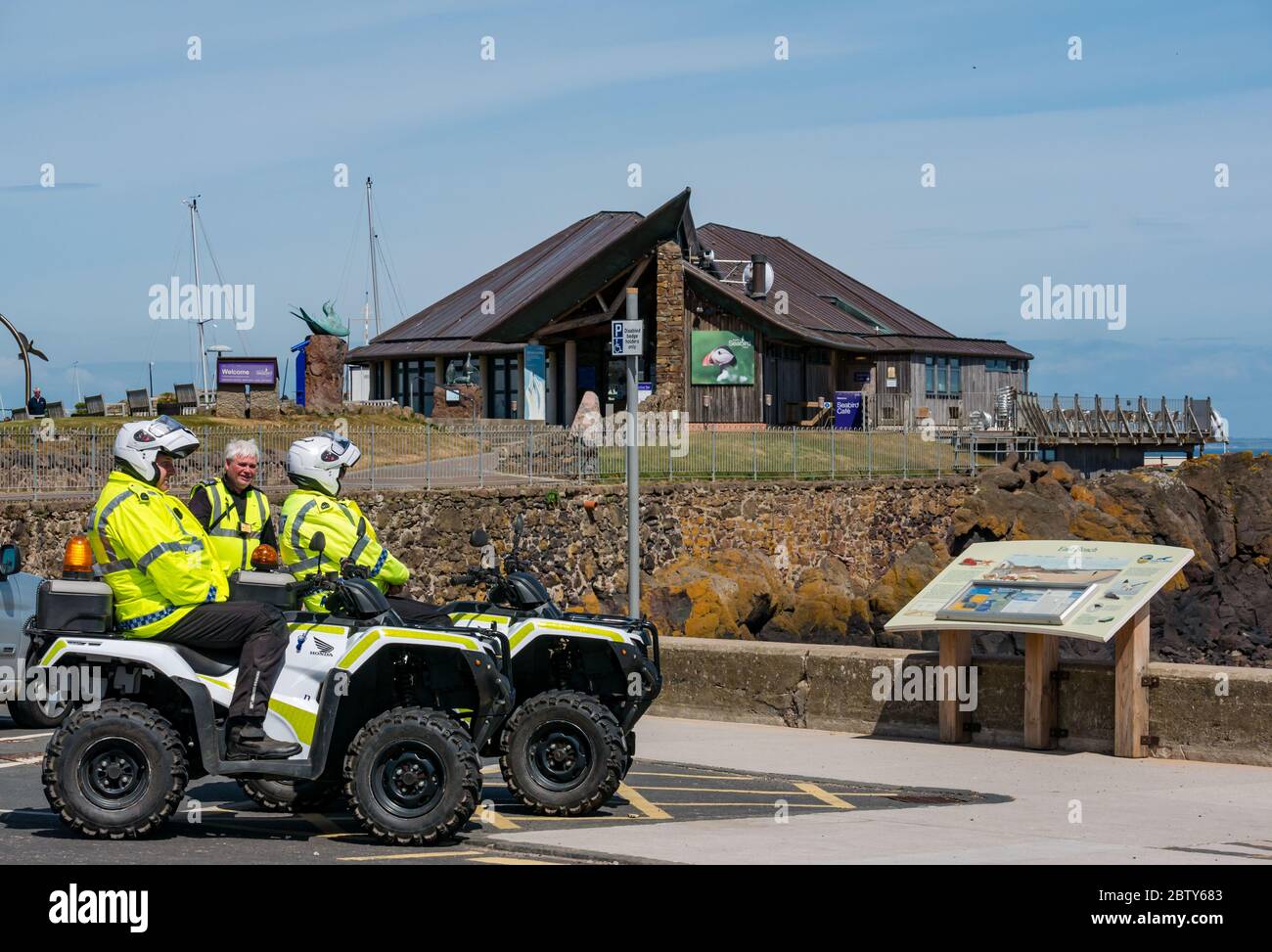 North Berwick, East Lothian, Scotland, United Kingdom, 28th May 2020. Easing of lockdown restrictions: with the Scottish Government set to announce the lifting of some lockdown restrictions today, there are already signs that things are beginning to return to normal in the popular seaside town. Police on quad bikes on patrol during the lockdown pause outside the Scottish Seabird Centre on a sunny day Stock Photo