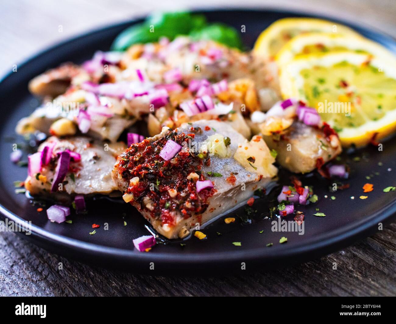 Marinated herring with dried tomatoes and onion Stock Photo