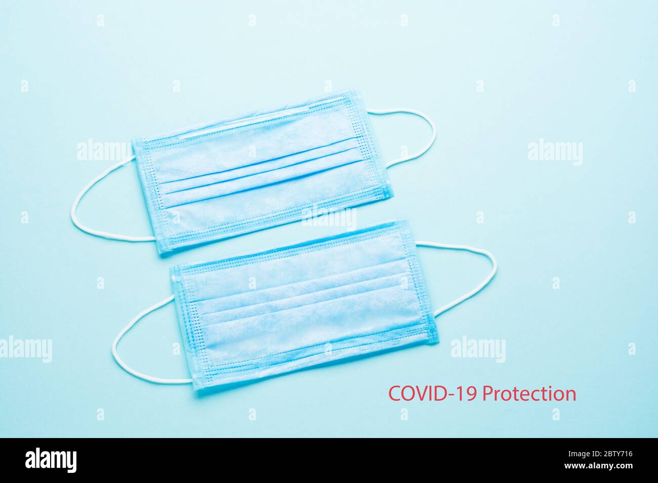 Blue Medical Disposable Face Mask with covid-19 printed on it. Coronavirus pneumonia gets official name from WHO: COVID-19. Disposable breath filter Stock Photo