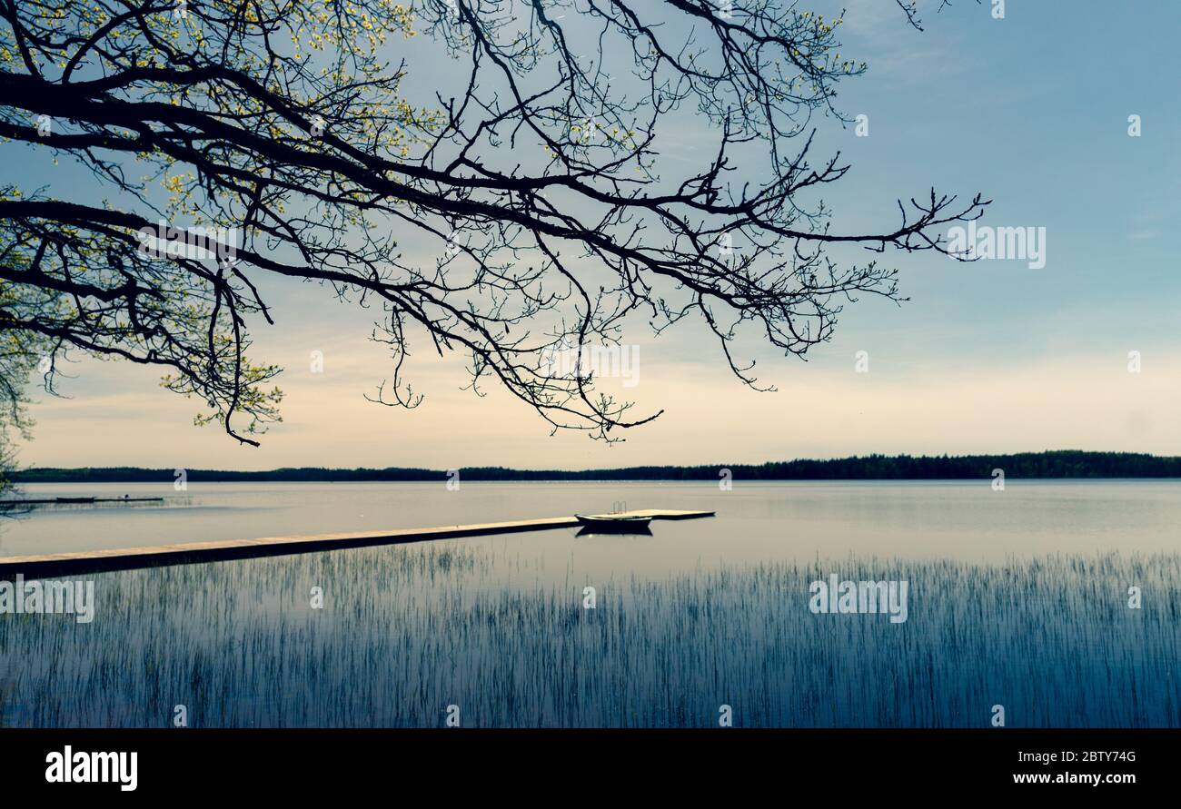 Wooden boat moored to a pier on a lake in spring Stock Photo - Alamy