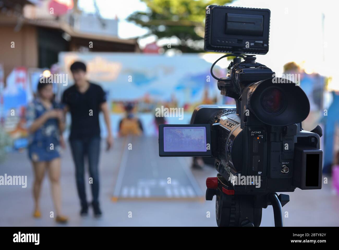 A video camera that uses live video streaming with actors walking in front  Stock Photo - Alamy