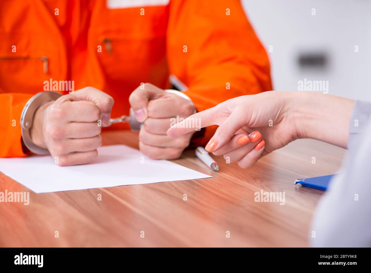 Young man meeting with advocate in pretrial detention Stock Photo