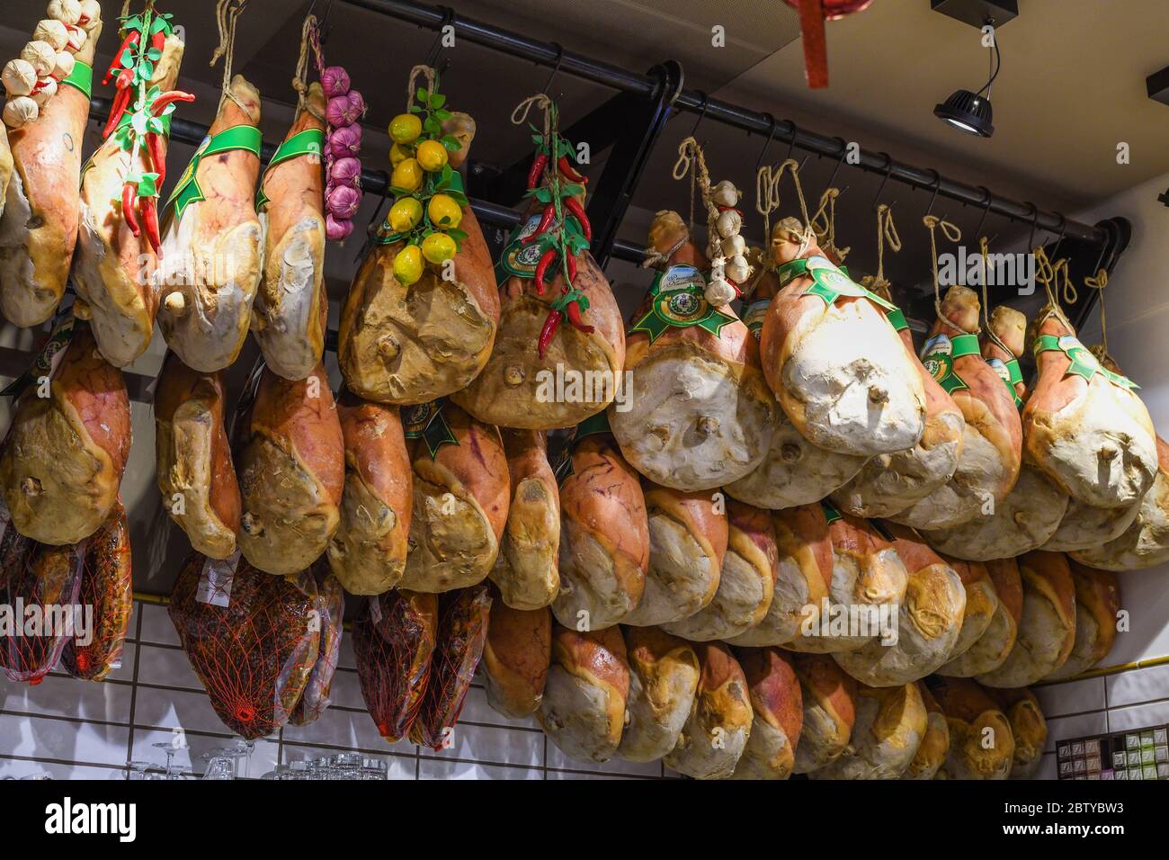 Prosciutto Nationale traditional ham or speck, whole pork pig leg smoked  and unsliced, hanging from the ceiling in an italian restaurant. Spiced and  g Stock Photo - Alamy