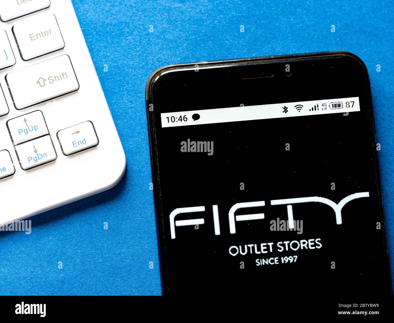 In this photo illustration a Fifty Outlet Stores logo seen displayed on a  smartphone Stock Photo - Alamy