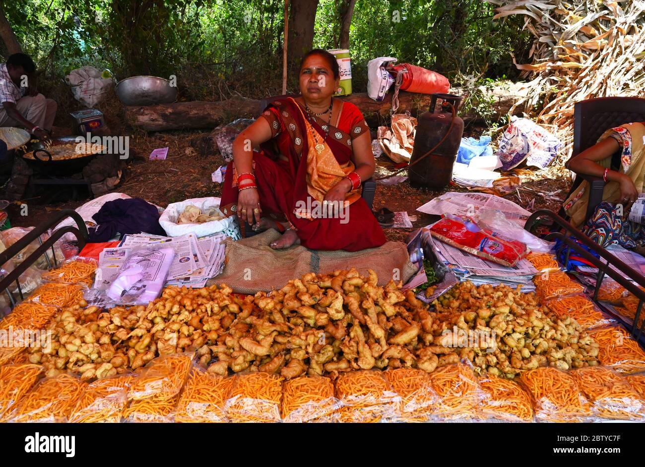 Adivasi woman selling freshly cooked pakora at traditional village fair celebrating Holi festival, Gujarat, India, Asia Stock Photo