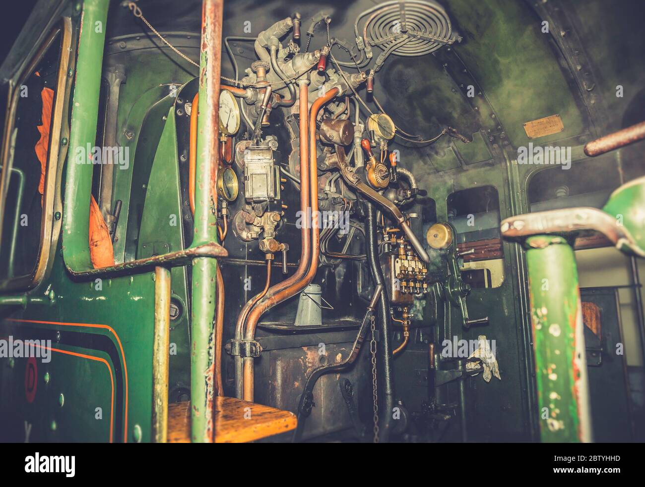 Atmospheric, close up of train driver controls inside vintage UK steam locomotive cab at night. Driving vintage trains. Stock Photo