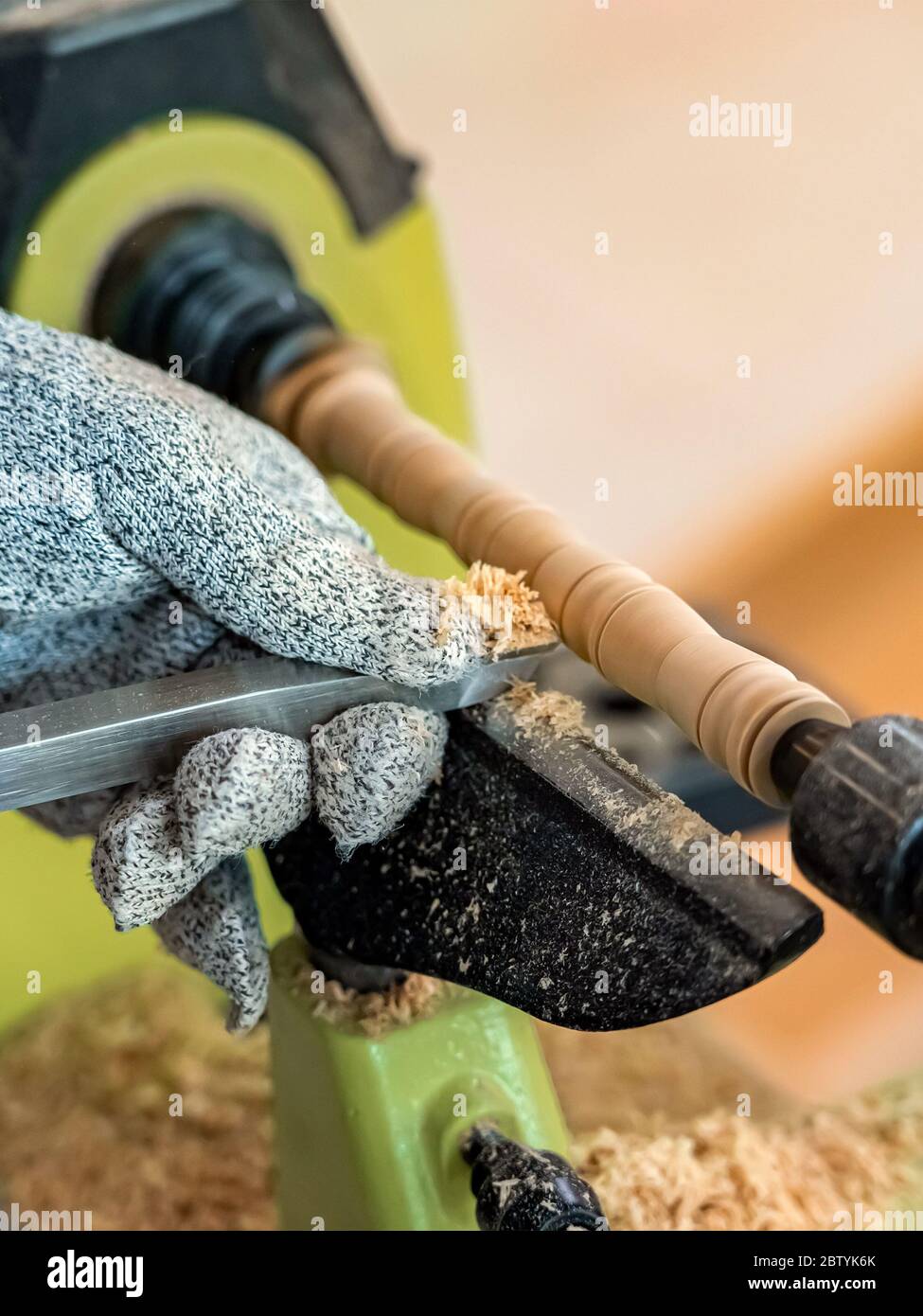 Carpenter man is carving the wooden stick. Spinning wood wheel machine