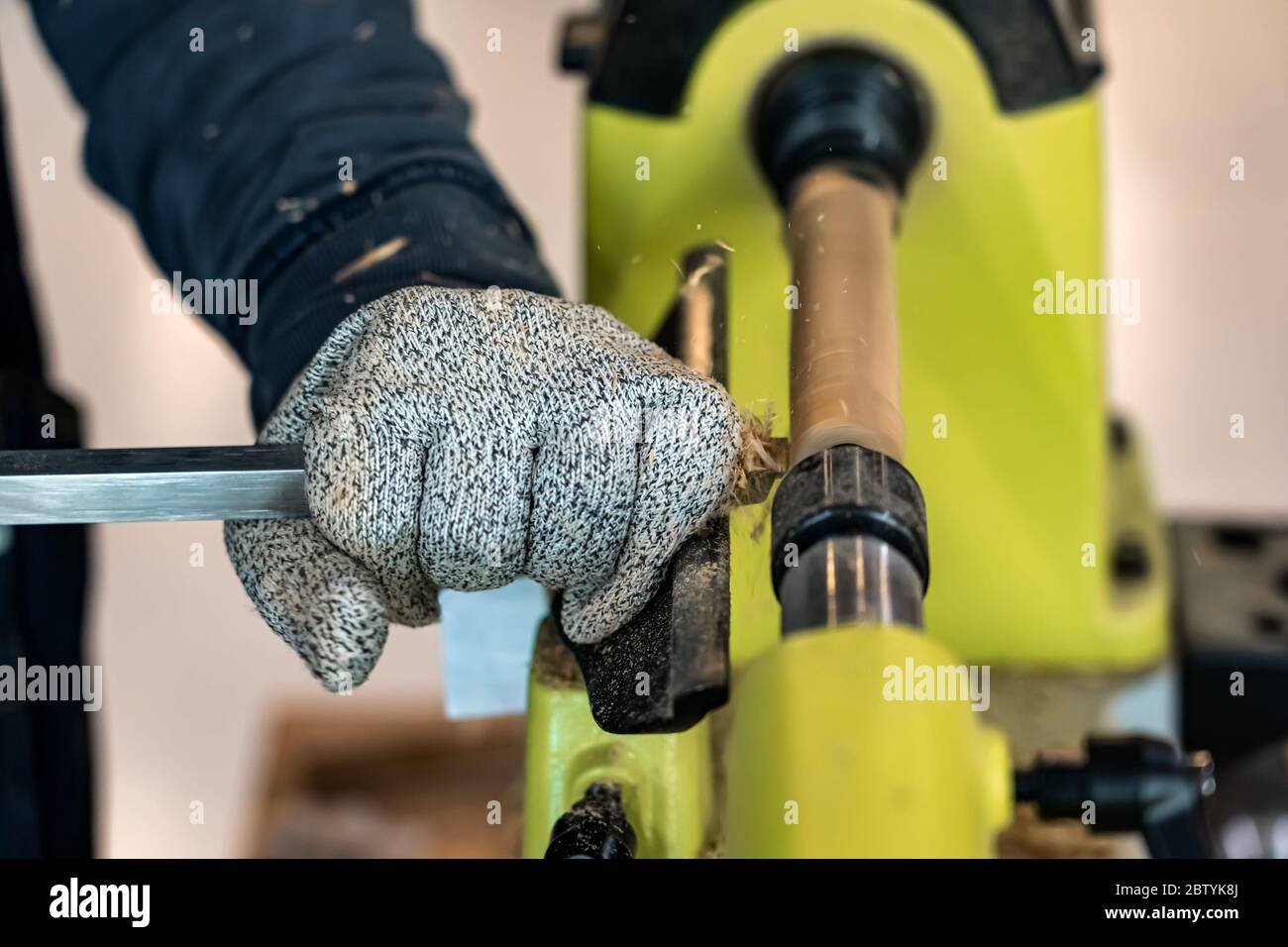 Carpenter man is carving the wooden stick. Spinning wood wheel machine