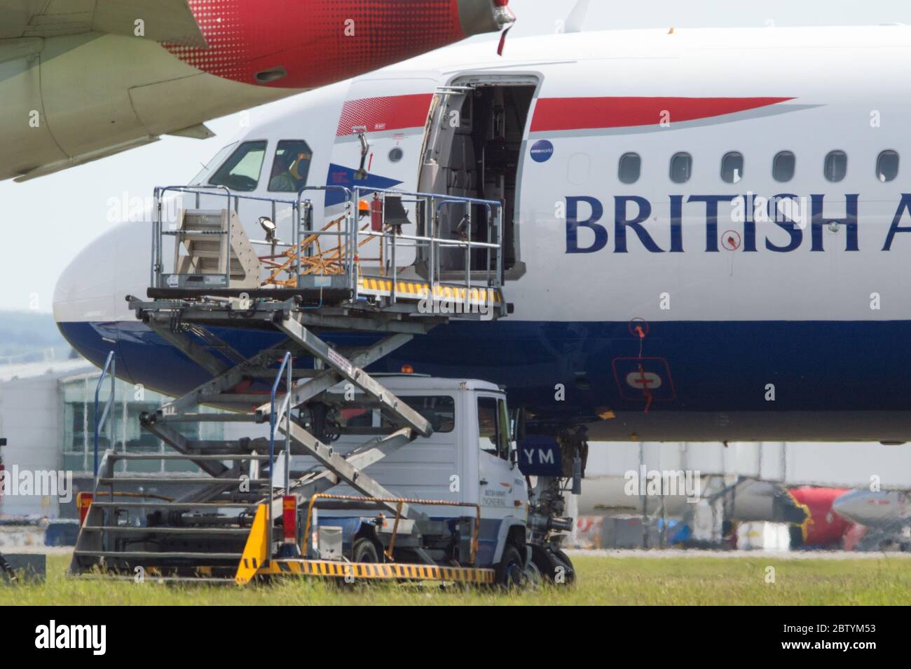 Glasgow, Scotland, UK. 28th May, 2020. Pictured: British Airways ground crews at Glasgow International Airport service the collection of grounded Airbus A319/A320/A321 aircraft which lie dormant and flightless as the airlines works out what to do with its mass of grounded planes in their fleet. There are fixed on going costs which BA must meet in order to make sure their planes are airworthy. To survive BA has already axed a quarter of their staff. Credit: Colin Fisher/Alamy Live News Stock Photo