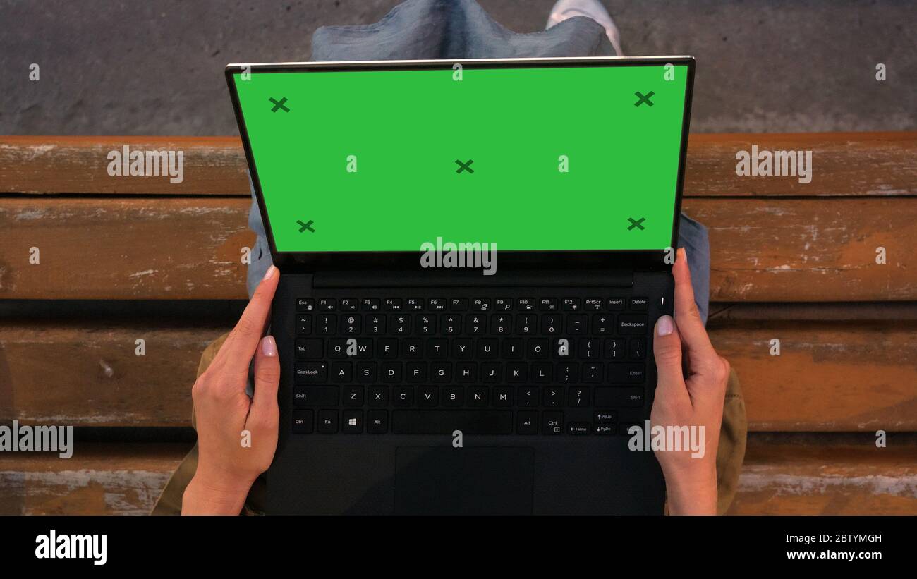 Woman sitting on a bench looking at Laptop screen. Stock Photo