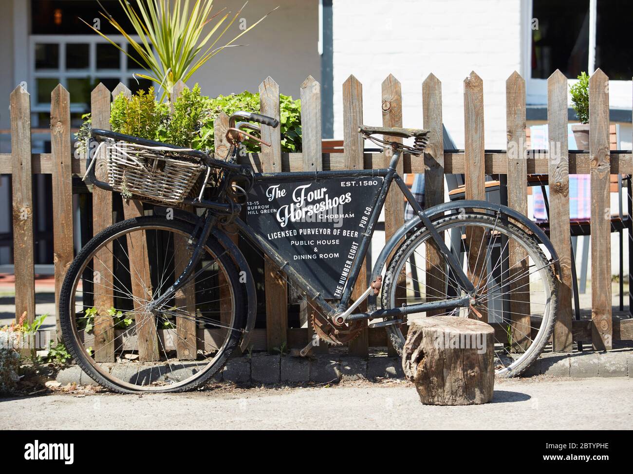 Traditional delivery bicycle outside the Four Horseshoes pub and restaurant, Chobham, Surrey, England, UK Stock Photo