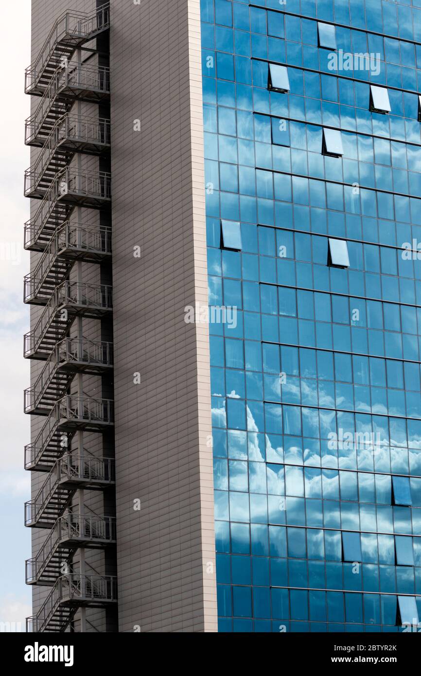 Office building fire escape and blue sky and clouds reflection or ...