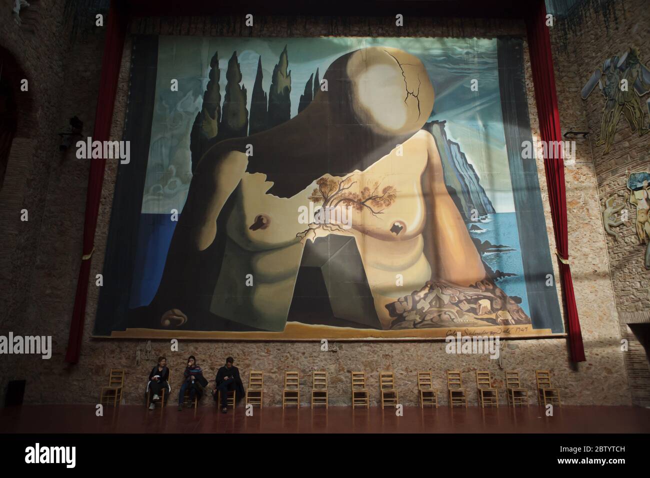 Visitors rest under the huge backdrop designed by Spanish surrealist painter Salvador Dalí for the ballet Labyrinth (1941) displayed in the Salvador Dalí Theatre and Museum in Figueres, Catalonia, Spain. Stock Photo