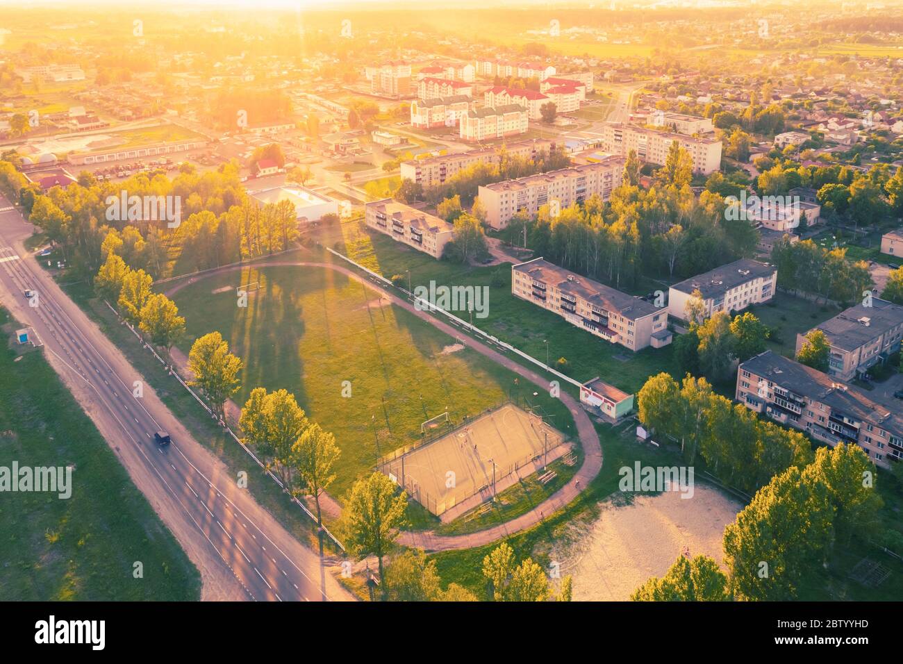 Stadium football soccer field, residential quarter in the city sports object landscape at sunset day with beautiful sunlight. Aerial view Stock Photo