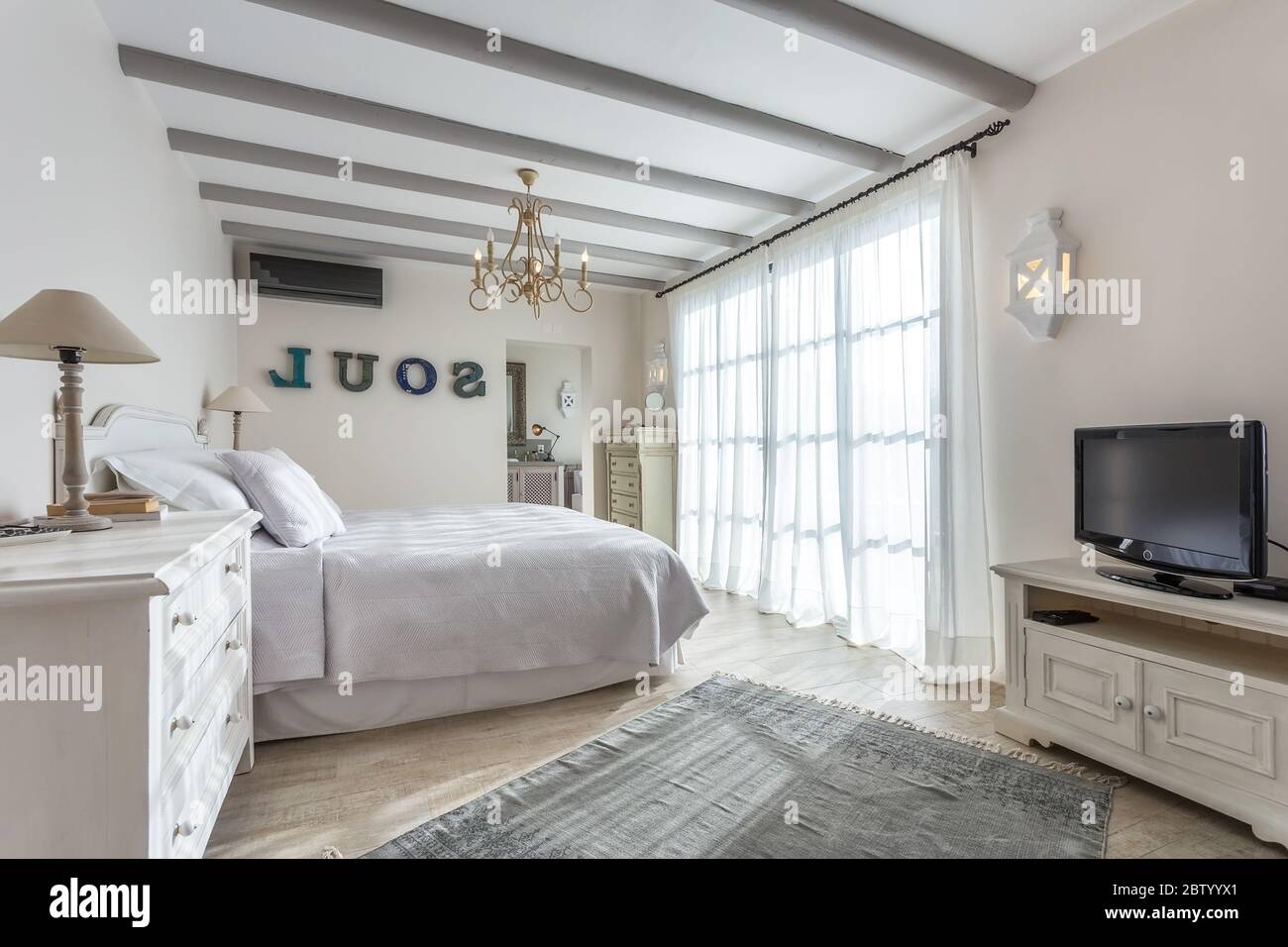 Luxury modern sunny bedroom with a large window. European hotel design. Stock Photo