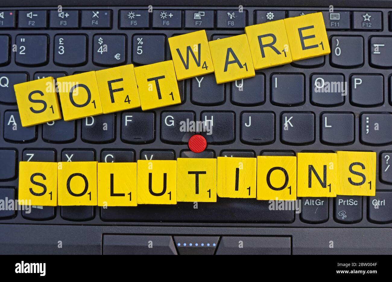 Software Solutions, spelt out in scrabble letters on a keyboard, software houses,Enterprise Software Solutions, business software,SME Solutions Stock Photo