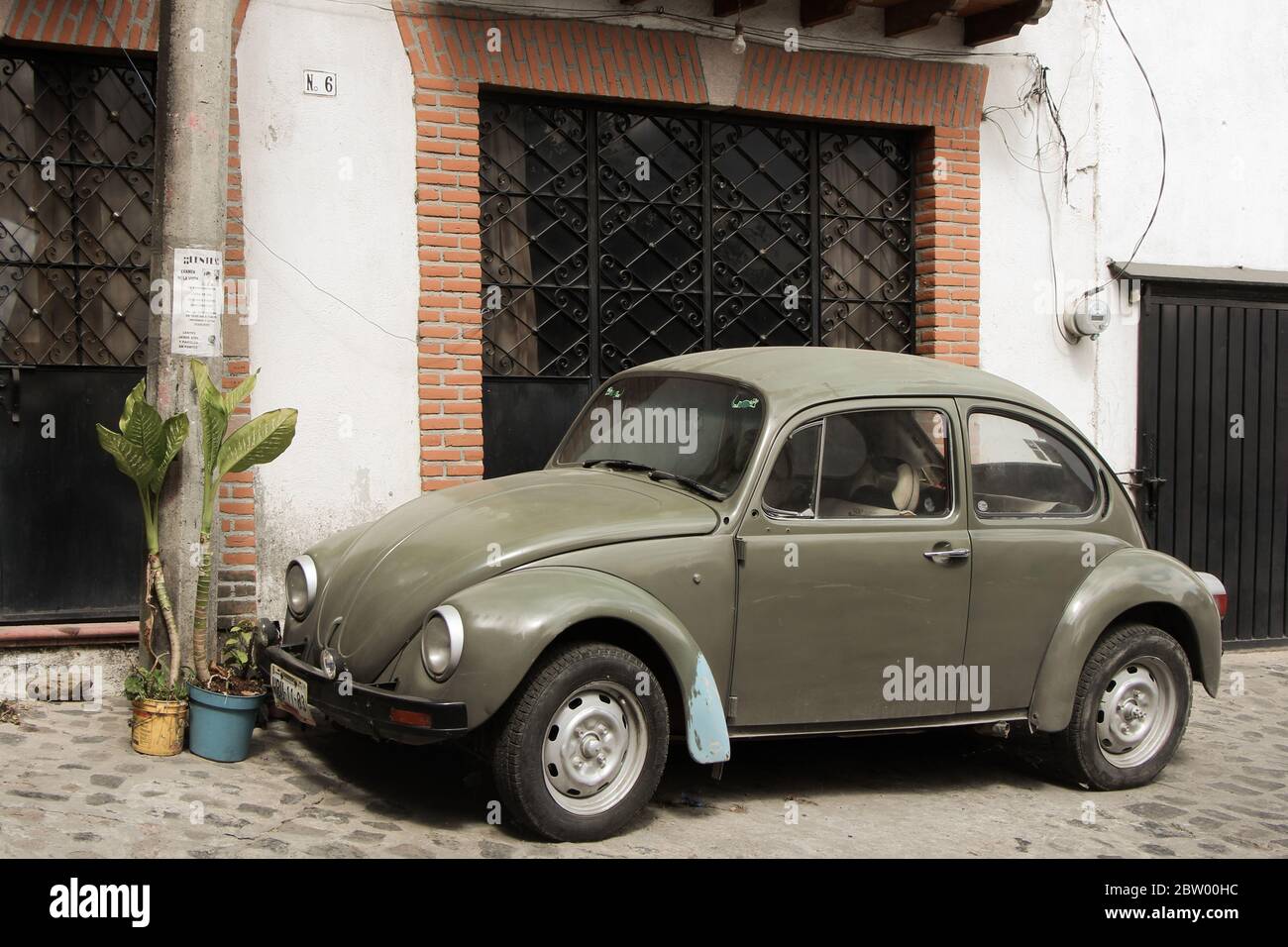 Beautiful Olive Green Beetle Car, Volkswagen, in steep street of Taxco, Guerrero, Mexico Stock Photo