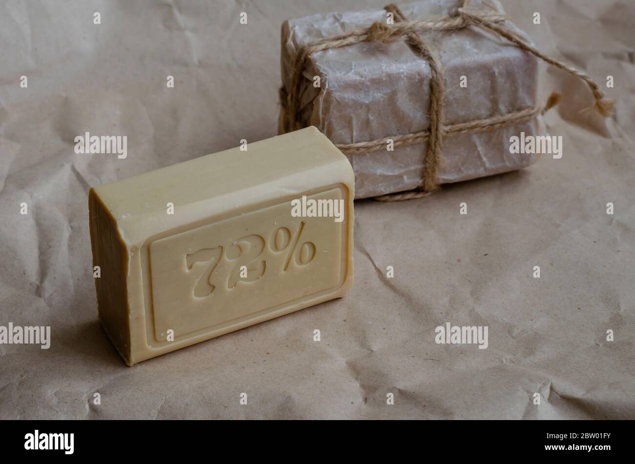 Pieces of laundry soap on a plain background. Two rectangular pieces of new soap wrapped with twine. Natural hygiene products. Place for text. Selecti Stock Photo