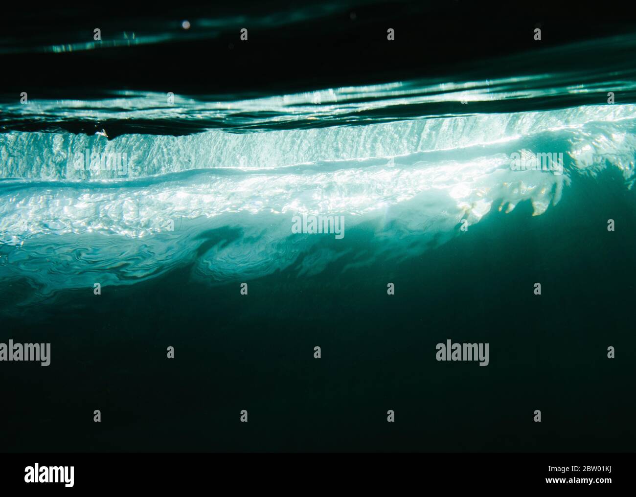 Cool light reflecting through a small wave underwater in Ireland Stock