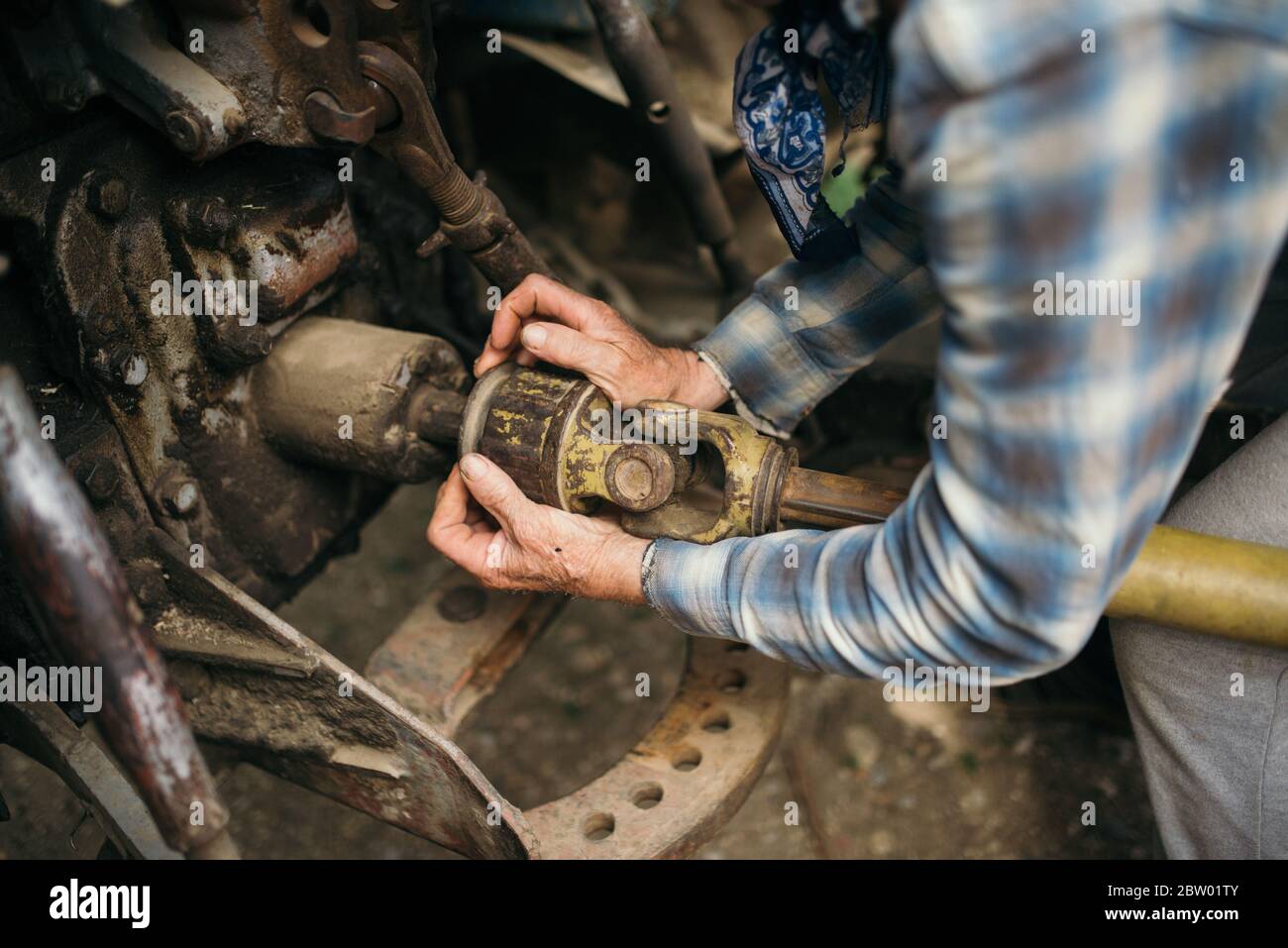 A mechanic is repairing a tractor used in agriculture closeup Stock
