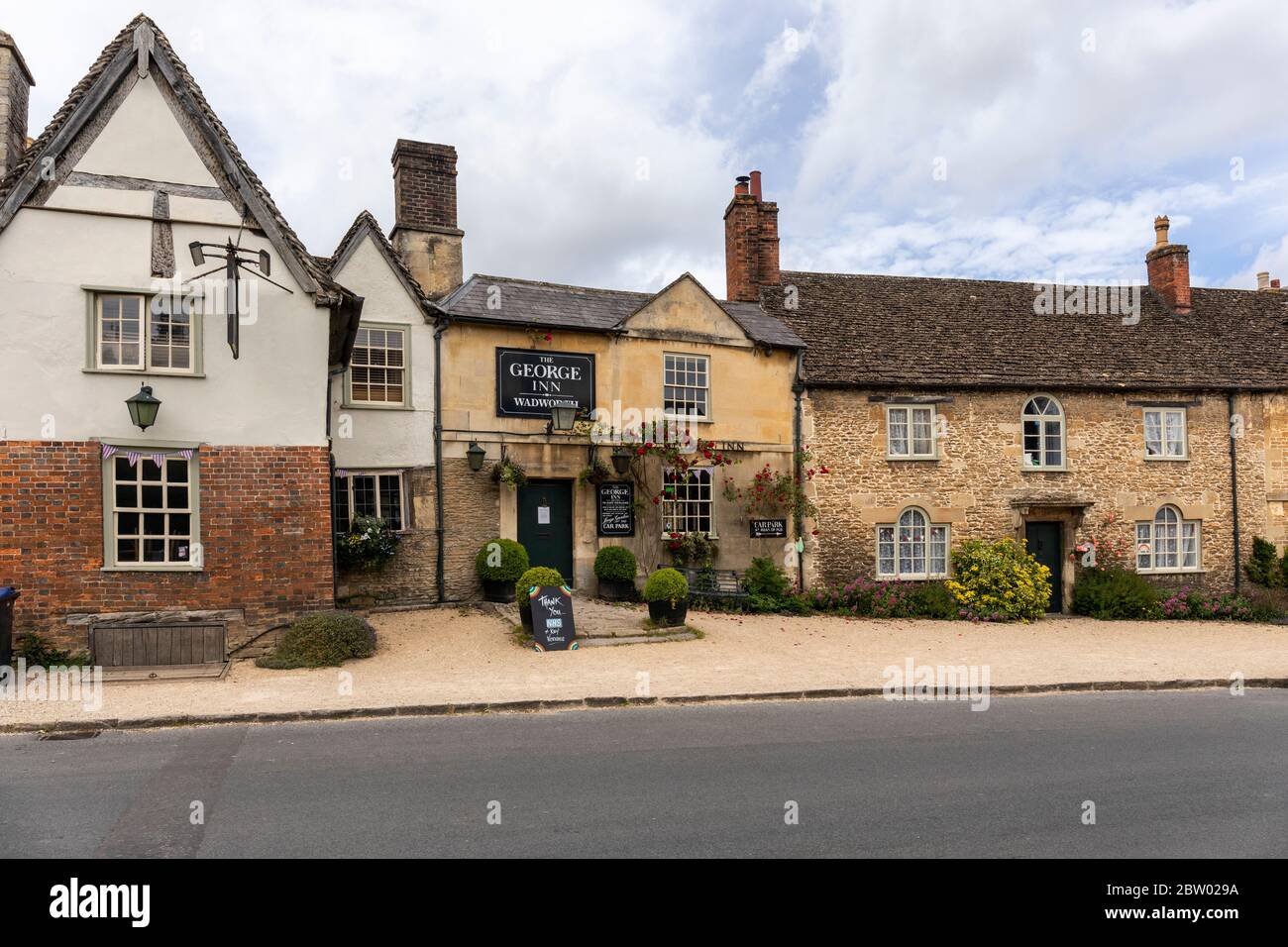 The George Inn and picturesque stone cottage in West Street, Lacock village, Wiltshire, England, UK ,Closed due to the Coronavirus (COVID‑19) pandemic Stock Photo