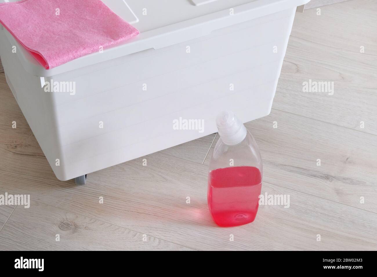 Cleaning concept in home. Plastic bottle with pink cleaning agent and