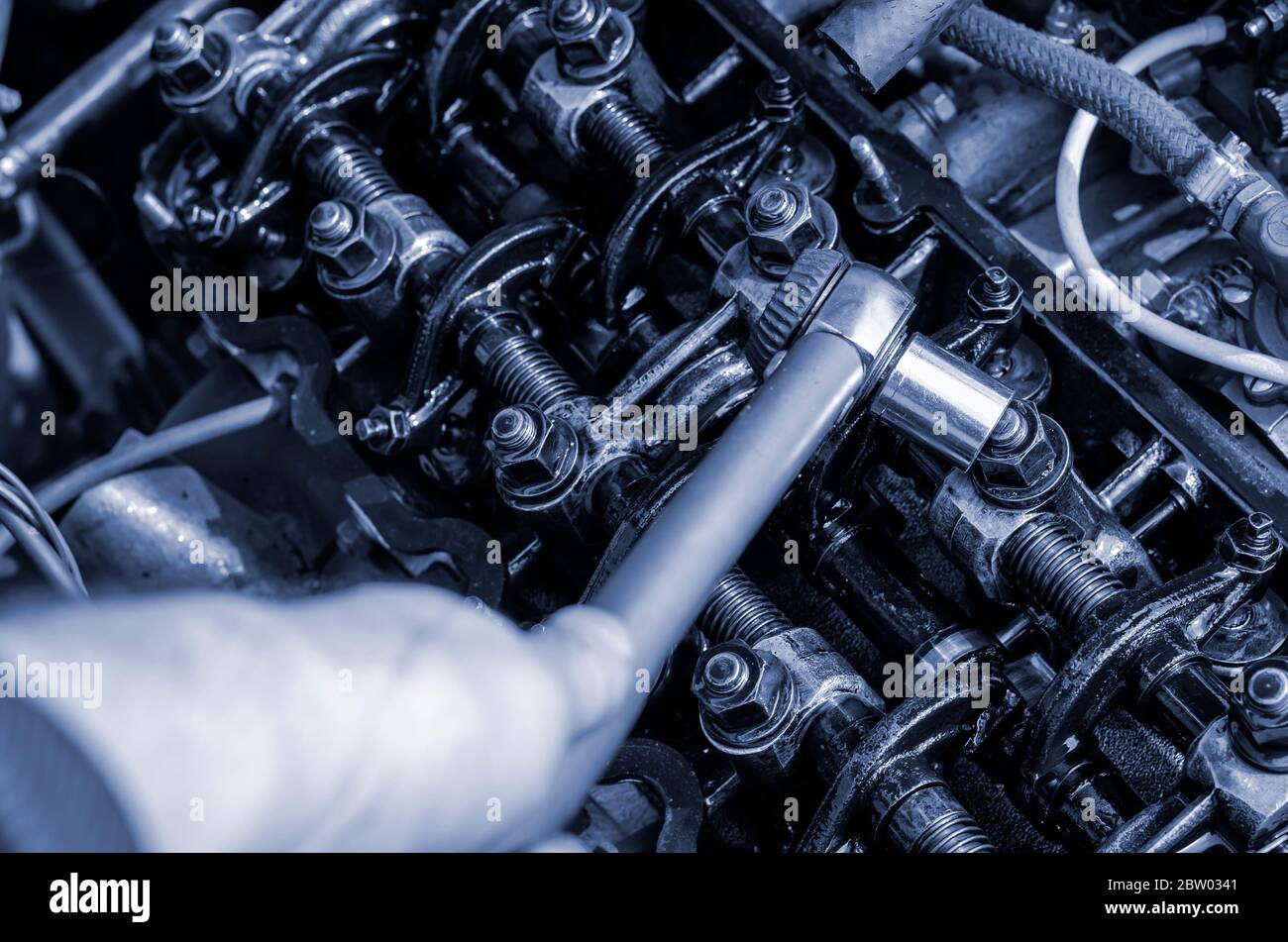 The engine compartment of a passenger car closeup. Tightening the cylinder head. Manual