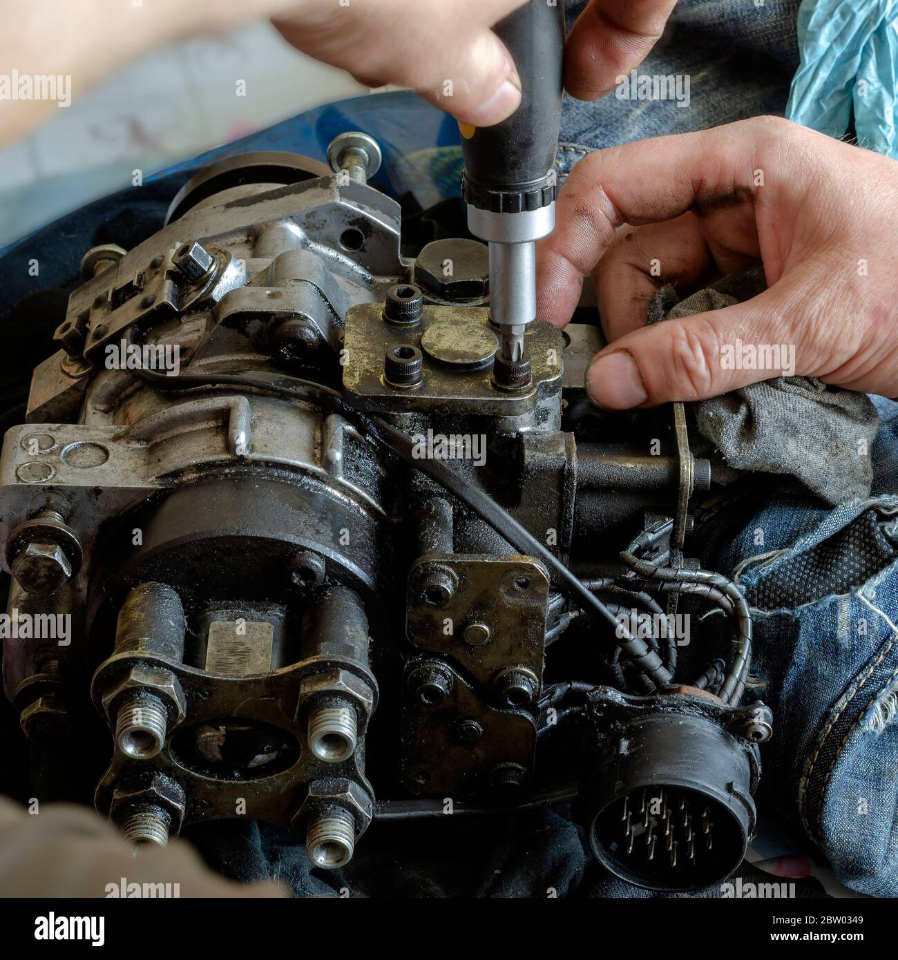 A mechanic disassembles and detects a fuel injection pump. The process
