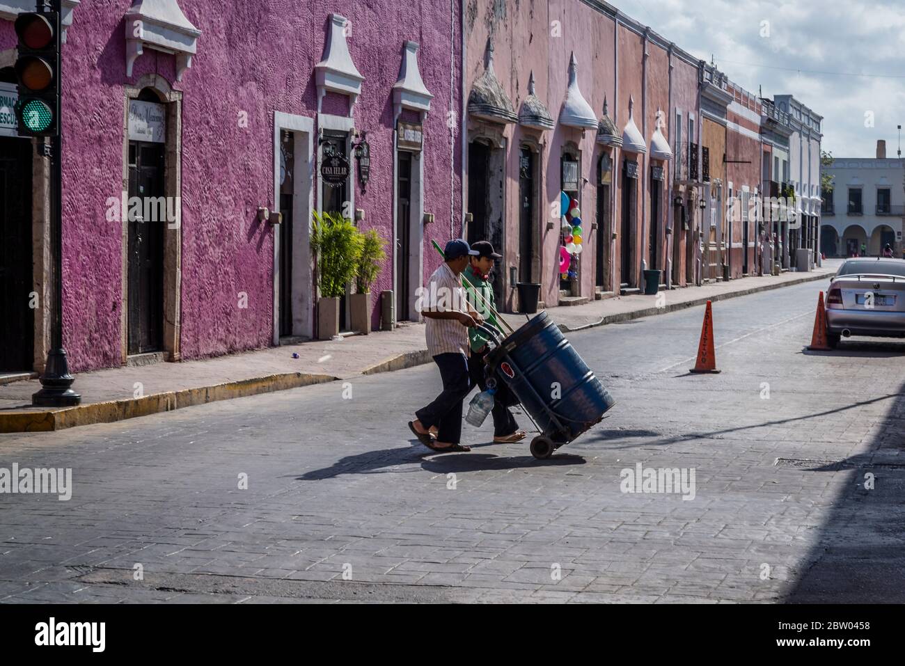 Street sweepers in typical street with beautiful pastel-painted houses, Valladolid, Yucatan, Mexico Stock Photo