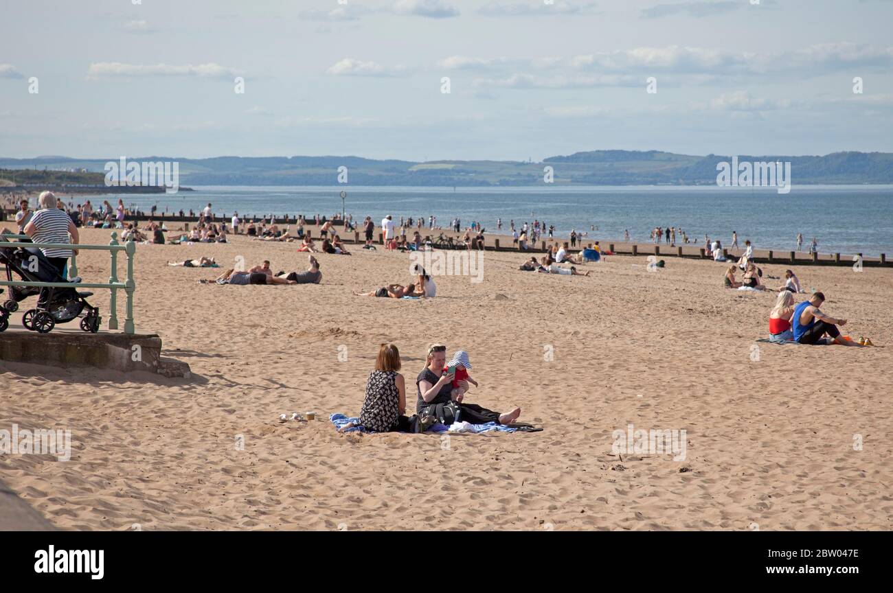 Portobello, Edinburgh, Scotland. 28 May 2020. 25 degrees late afternoon at the seaside. Reasonably busy beach and promenade with the Police in attendance continuing with the pass through but not bothering to talk to anyone regarding sitting around as the Scottish First Minister eases some of the restrictions for the Scottish public. Stock Photo