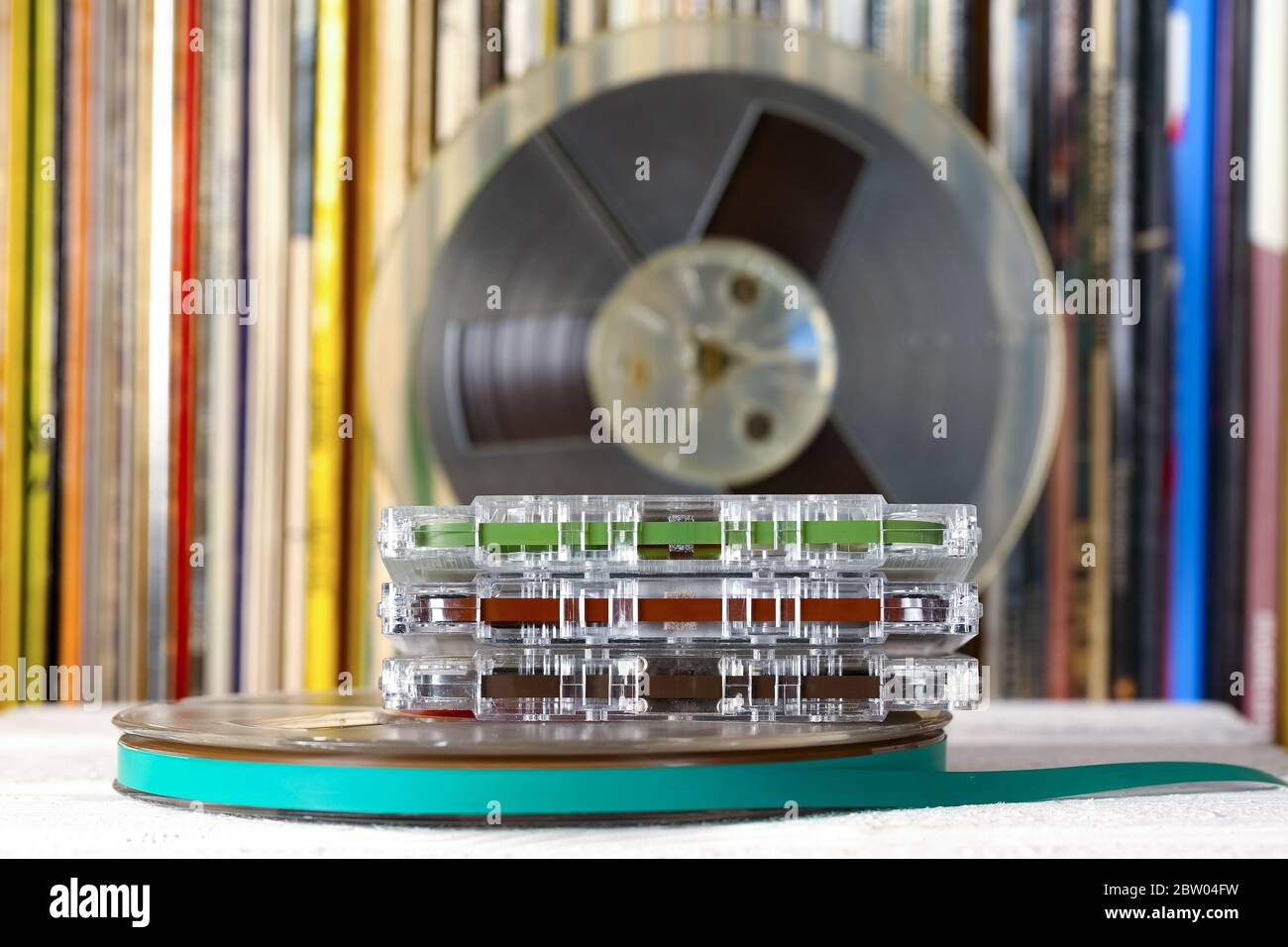 Compact cassettes and reel tapes are shown on the background of vinyl