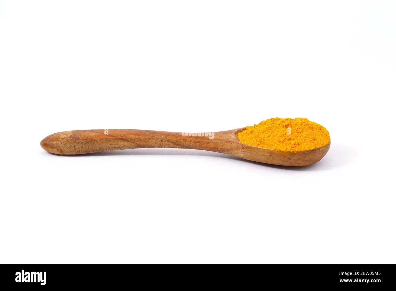 Turmeric powder in a wooden spoon Stock Photo