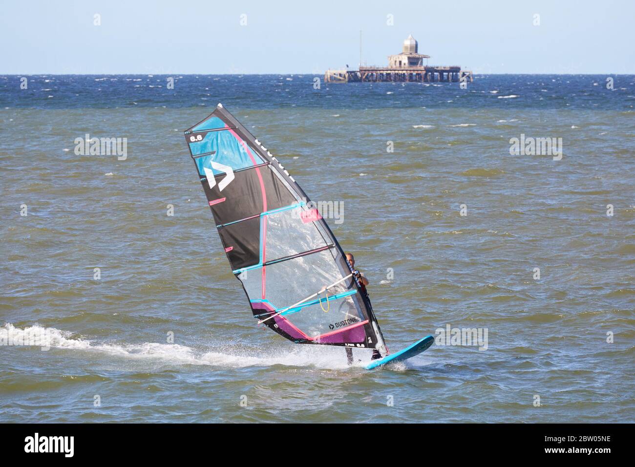 Herne Bay, Kent, UK. 28th May 2020: UK Weather. Kite surfers and windsurfers take advantage of the North East breeze with the abandoned old pier head beyond on a fine sunny day which is cooler than it has been. Credit Alan Payton/Alamy Live News Stock Photo