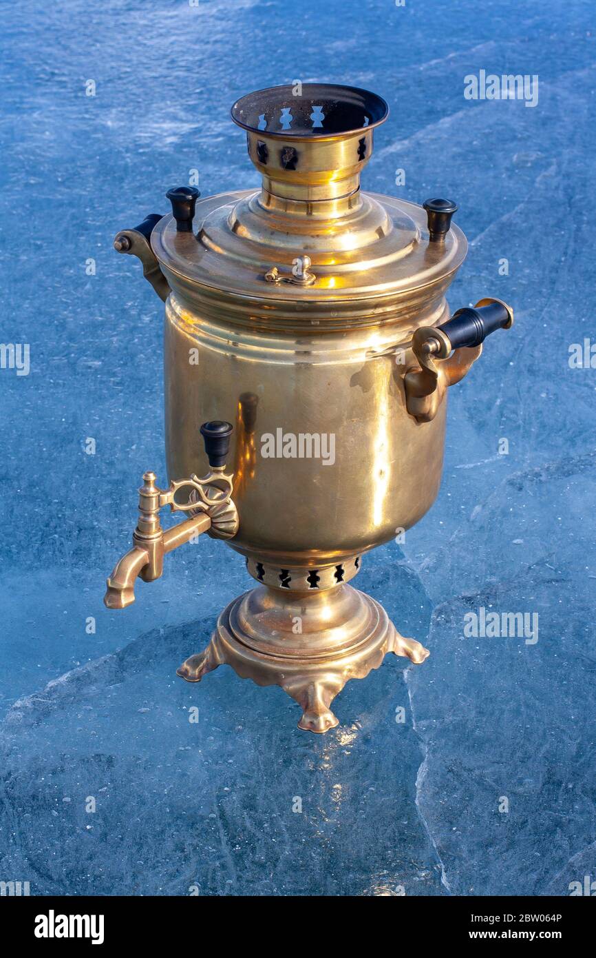https://c8.alamy.com/comp/2BW064P/retro-samovar-stands-on-the-lake-people-a-russian-kettle-works-on-firewood-made-of-copper-and-brass-cracks-in-the-blue-ice-vertical-2BW064P.jpg