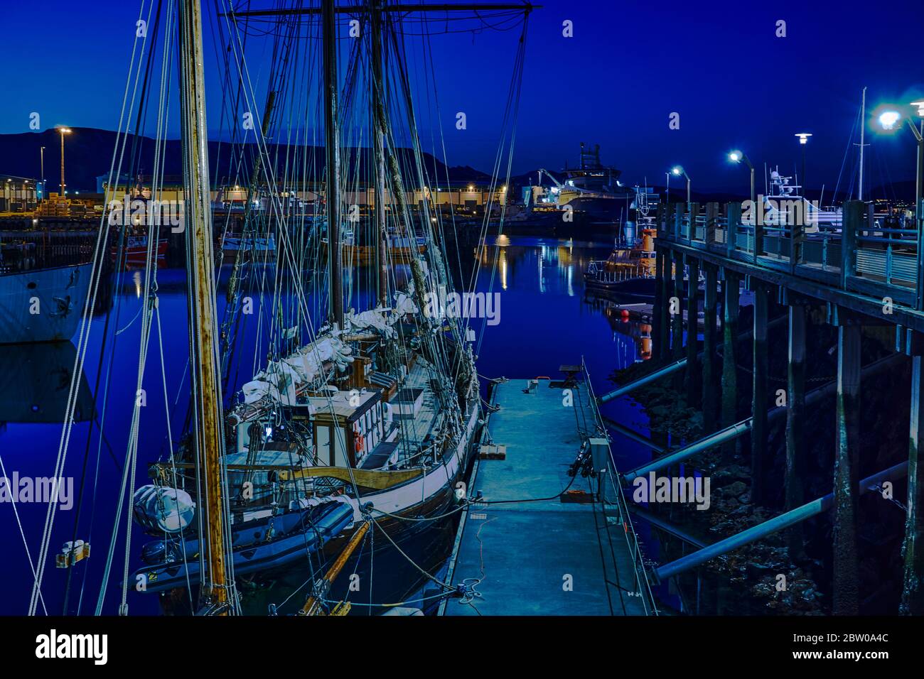 Early summer night view over Reykjavik harbour, boats, lights in the blue light of midnight Stock Photo