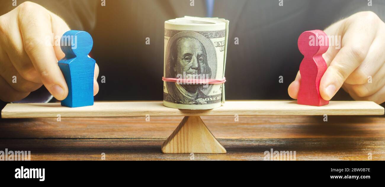 The businessman puts the figure of a man and a woman on the scales with money. Concept of gender pay gap. Income inequality. Oppression of women. Gend Stock Photo