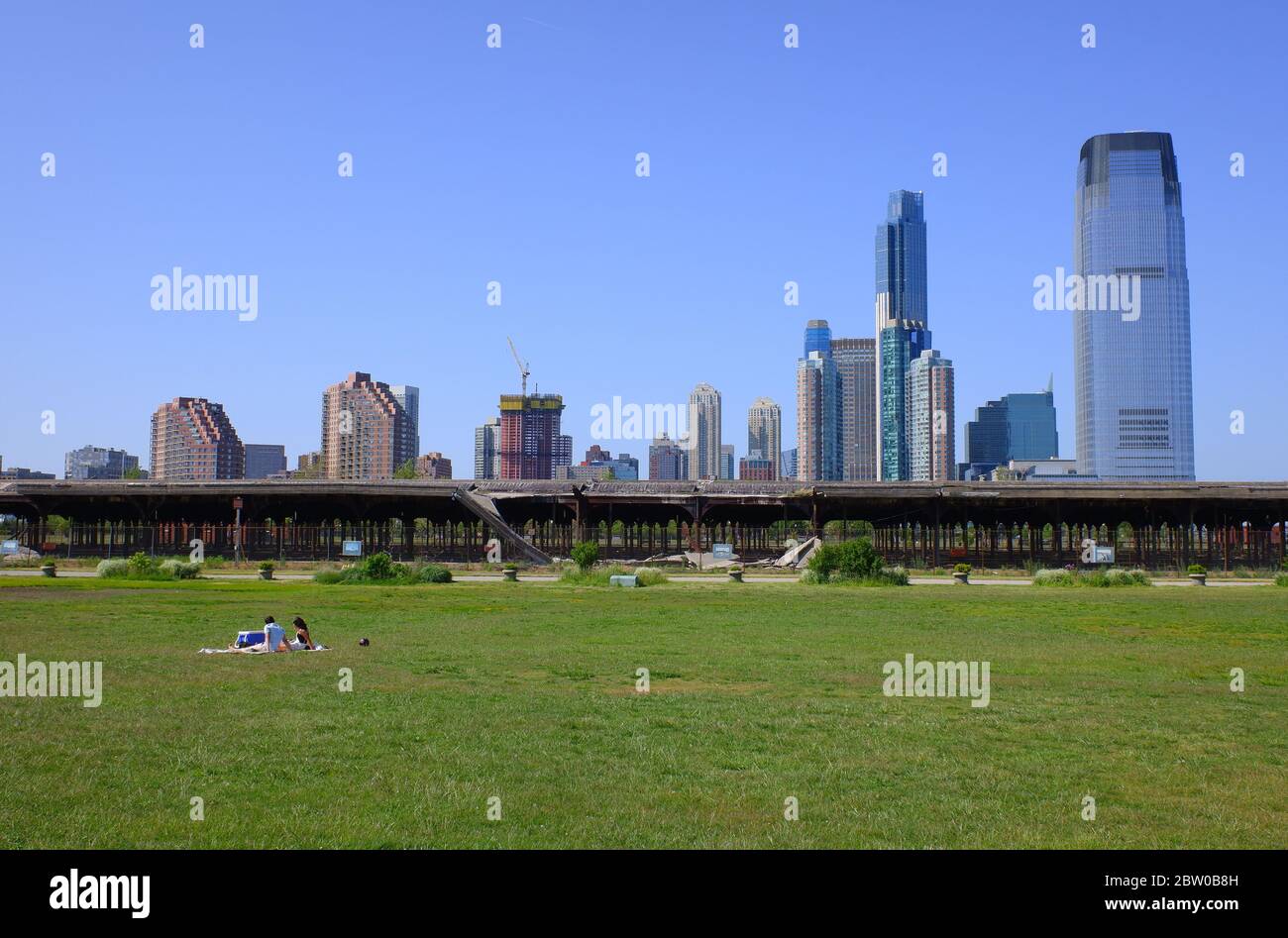 Almost empty grass field in Liberty State Park during covid-19 coronavirus  pandemic crisis with the skyline of Jersey City in the background.New Jersey.USA Stock Photo
