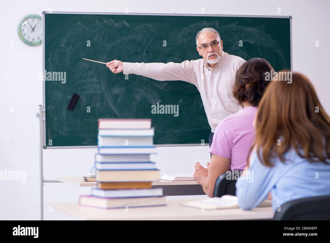 Old teacher and two students in the classroom Stock Photo - Alamy