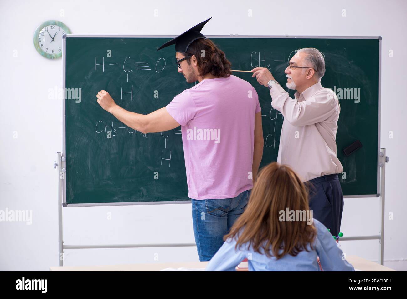 Old teacher and two students in the classroom Stock Photo - Alamy