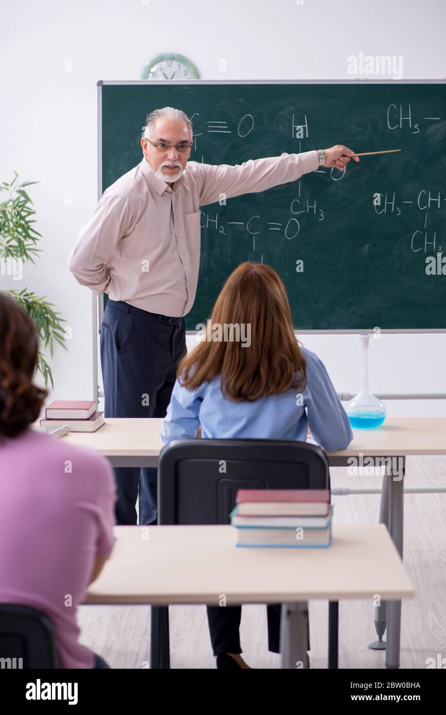 Old teacher and two students in the classroom Stock Photo - Alamy