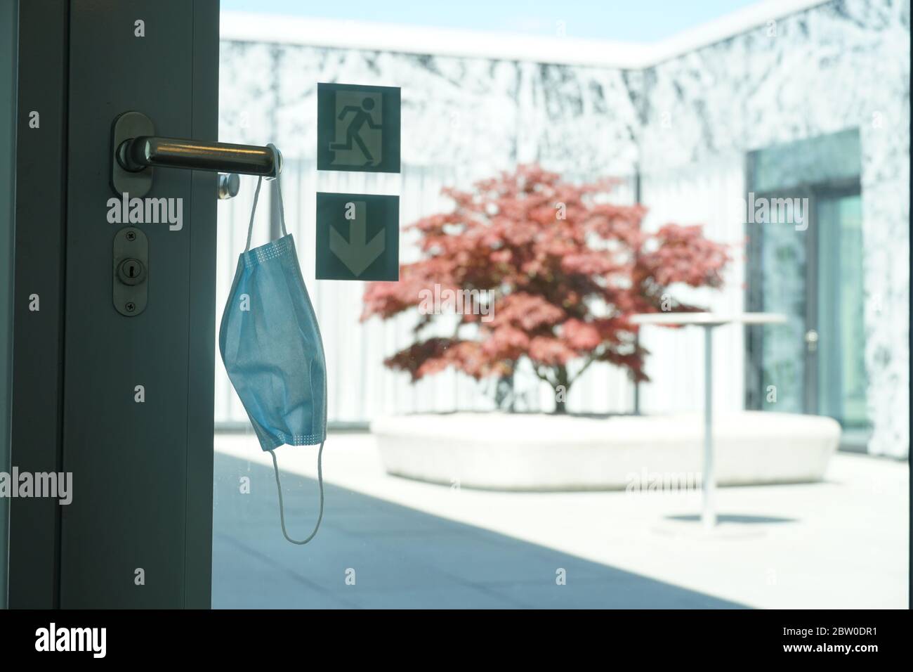 A face mask hung on a door handle to the pause terrace of a corporate ...