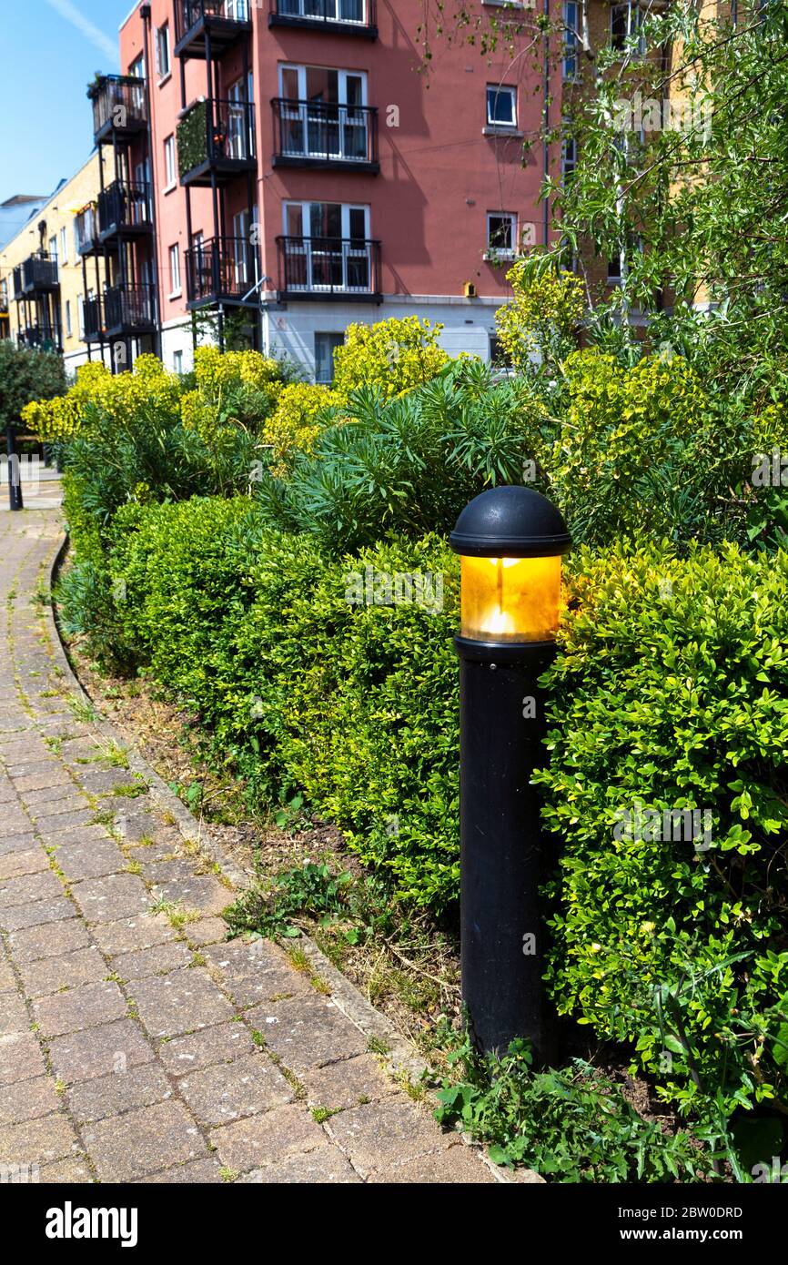 Street lantern light on during the day, wasting electricity, London, UK Stock Photo