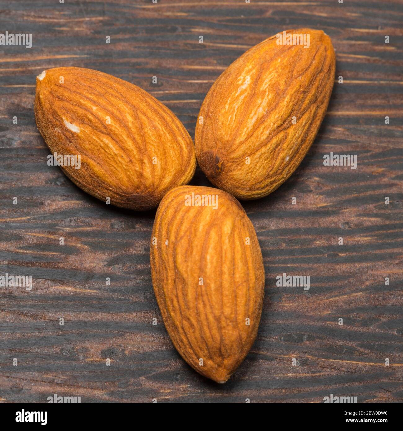 Close-up view of almonds on black wooden background. Stock Photo