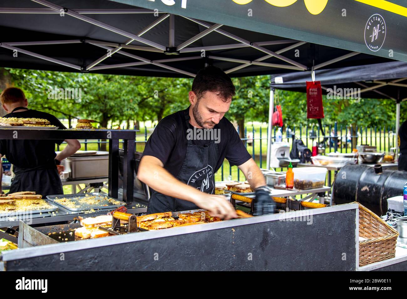 Chef preparing grilled cheese sandwiches at the Meltsmiths stall in Victoria Park Market, London, UK Stock Photo